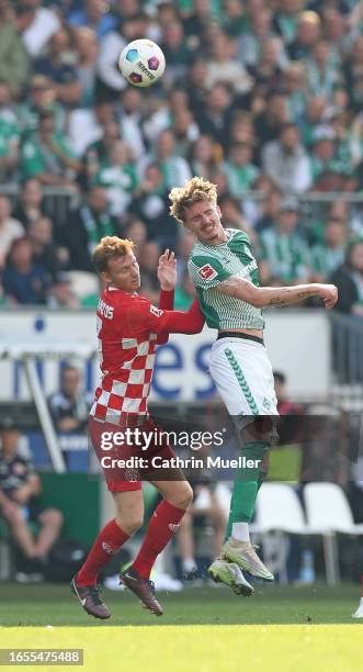 Sepp van den Berg of FSV Mainz 05 and Nick Woltemade of Werder Bremen battle for the ball during the Bundesliga match between SV Werder Bremen and 1....