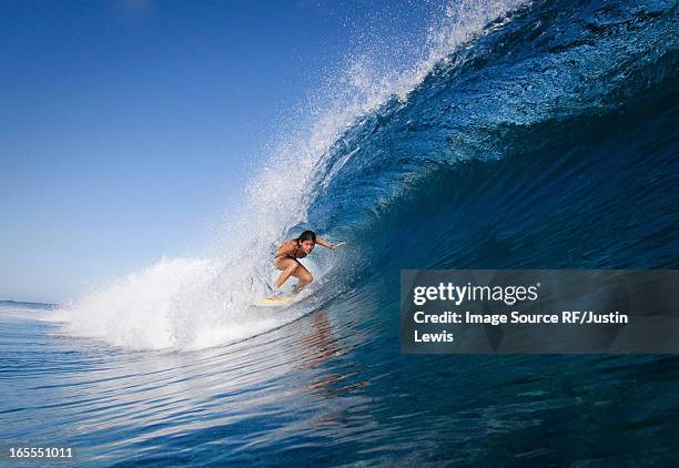 woman surfing in crest of wave - woman surfing stock pictures, royalty-free photos & images