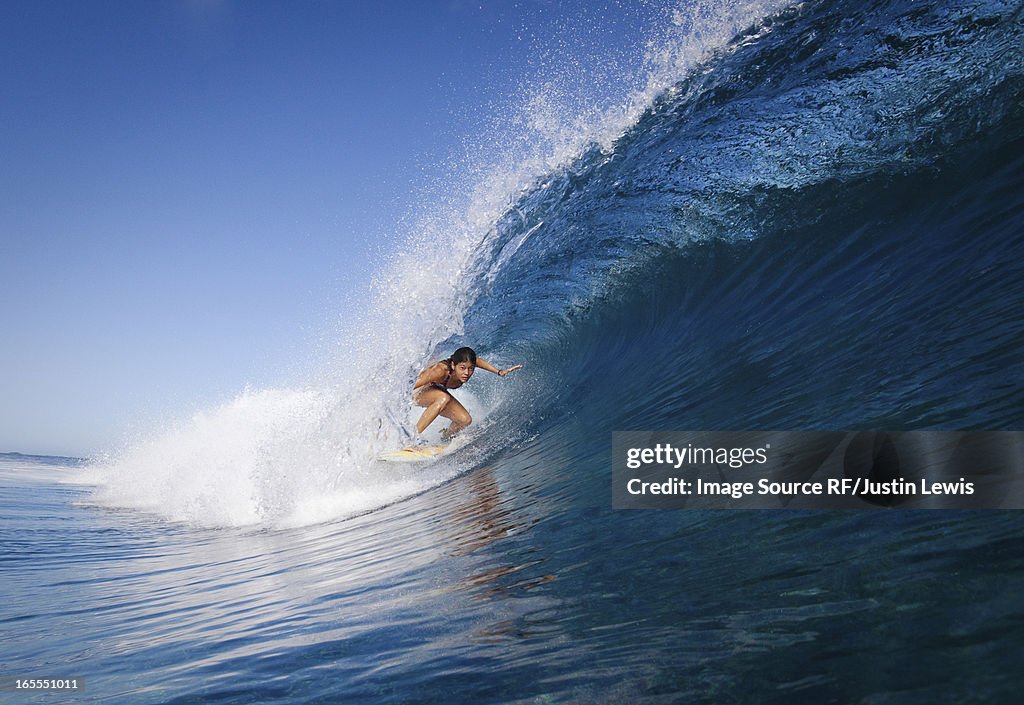 Woman surfing in crest of wave