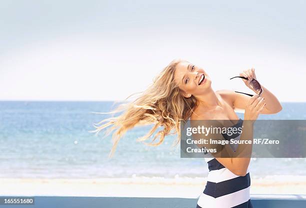 woman tossing her hair on beach - human hair strand stock pictures, royalty-free photos & images