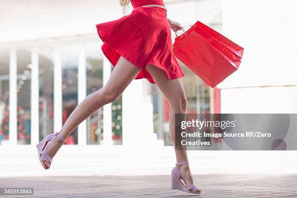 woman carrying shopping bag outdoors - 美脚 ストックフォトと画像