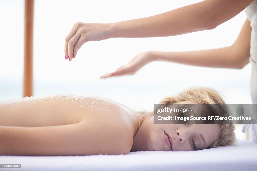 Woman having salt scrub on beach