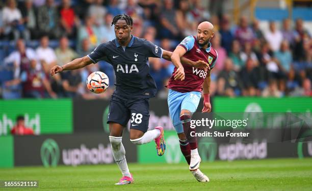 Burnley player Nathan Redmond is challenged by Destiny Udogie of Spurs during the Premier League match between Burnley FC and Tottenham Hotspur at...