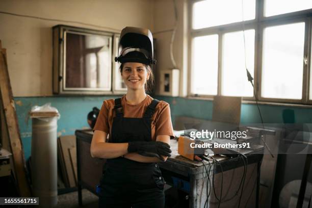 porträt einer kaukasischen schweißerin mit arbeitsschutzkleidung - porträt auszubildender stock-fotos und bilder