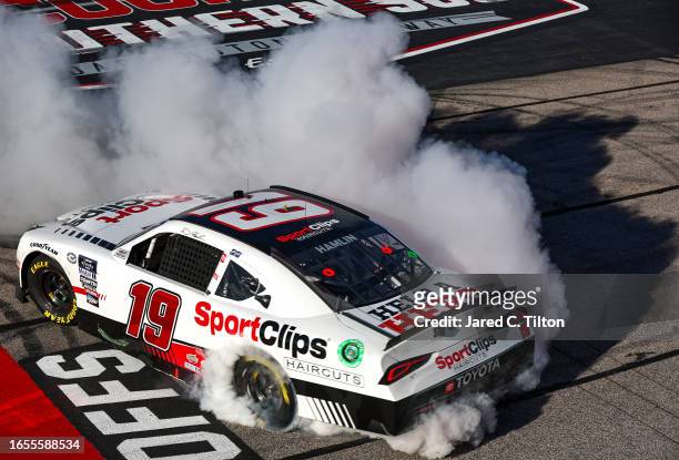 Denny Hamlin, driver of the Sport Clips Haircuts Toyota, celebrates with a burnout after winning the NASCAR Xfinity Series Sport Clips Haircuts VFW...