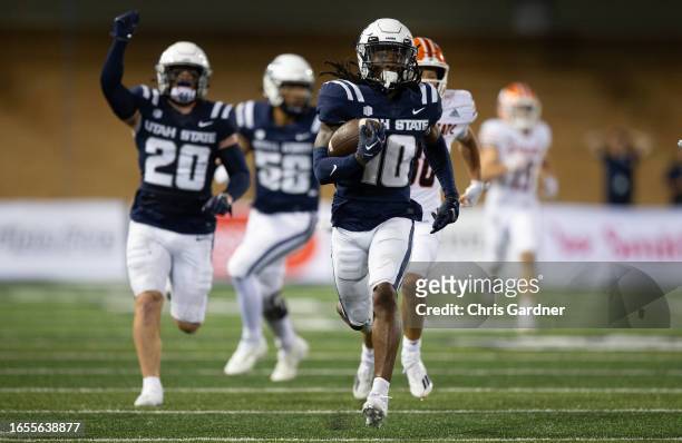 Jaiden Francois of the Utah State Aggies runs back an interception for a touchdown against the Idaho State Bengals during the second half of their...