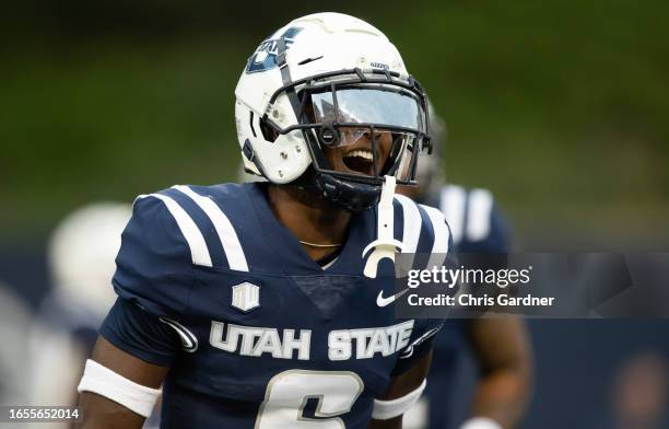 Ike Larsen of the Utah State Aggies celebrates scoring after an interception against the Idaho State Bengals during the first half of their game at...