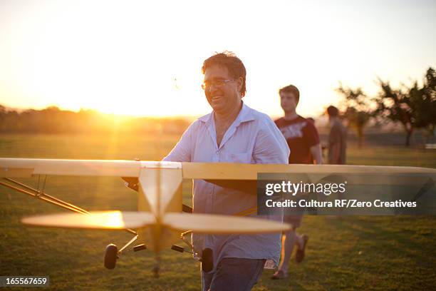 men playing with toy airplane in park - model airplane stock pictures, royalty-free photos & images