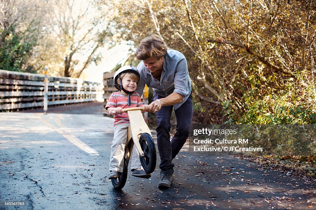 Father teaching son to ride bicycle