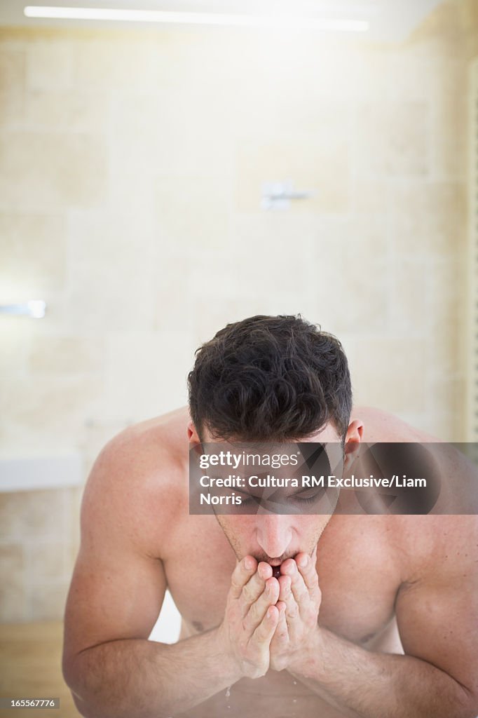 Man washing his face in bathroom