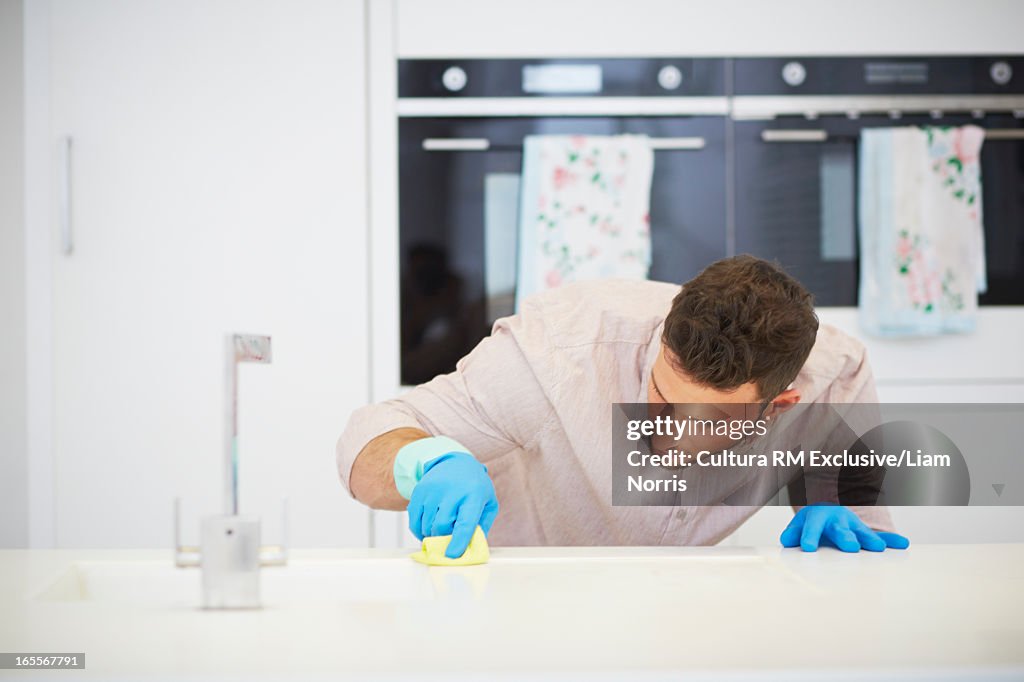 Man carefully scrubbing kitchen