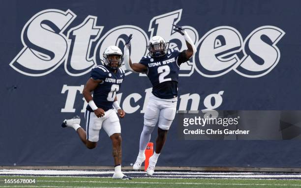 Robert Briggs of the Utah State Aggies celebrates scoring a touchdown with teammate Terrell Vaughn against the Idaho State Bengals during the first...