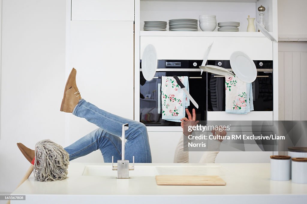 Man falling with dishes in kitchen