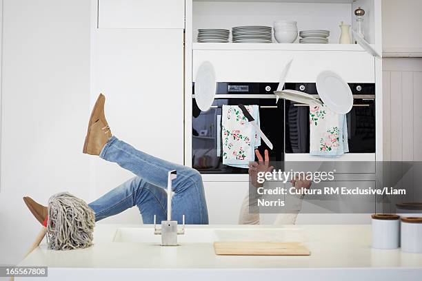 man falling with dishes in kitchen - tropeçar imagens e fotografias de stock