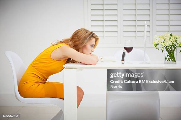 bored woman using cell phone at table - staring stock pictures, royalty-free photos & images