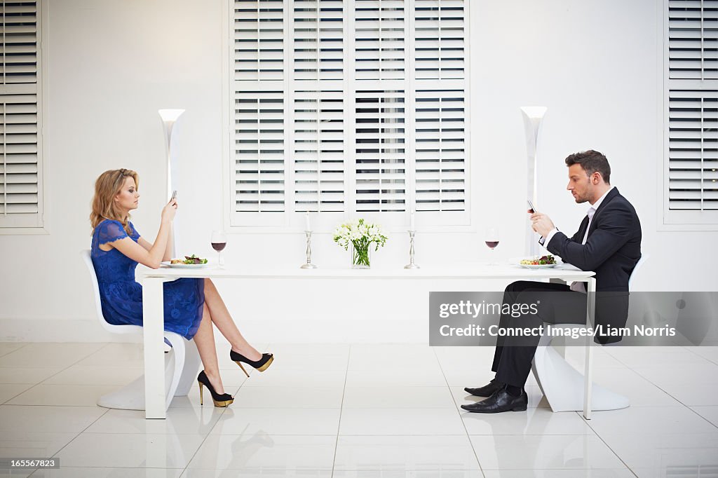 Distant couple having dinner together