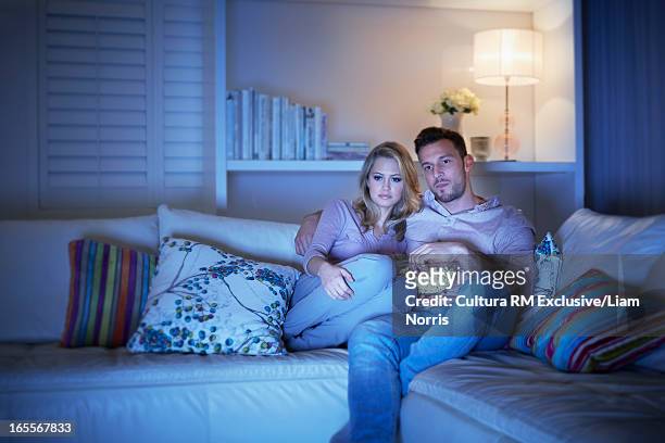 couple watching television on sofa - girlfriends films stock-fotos und bilder