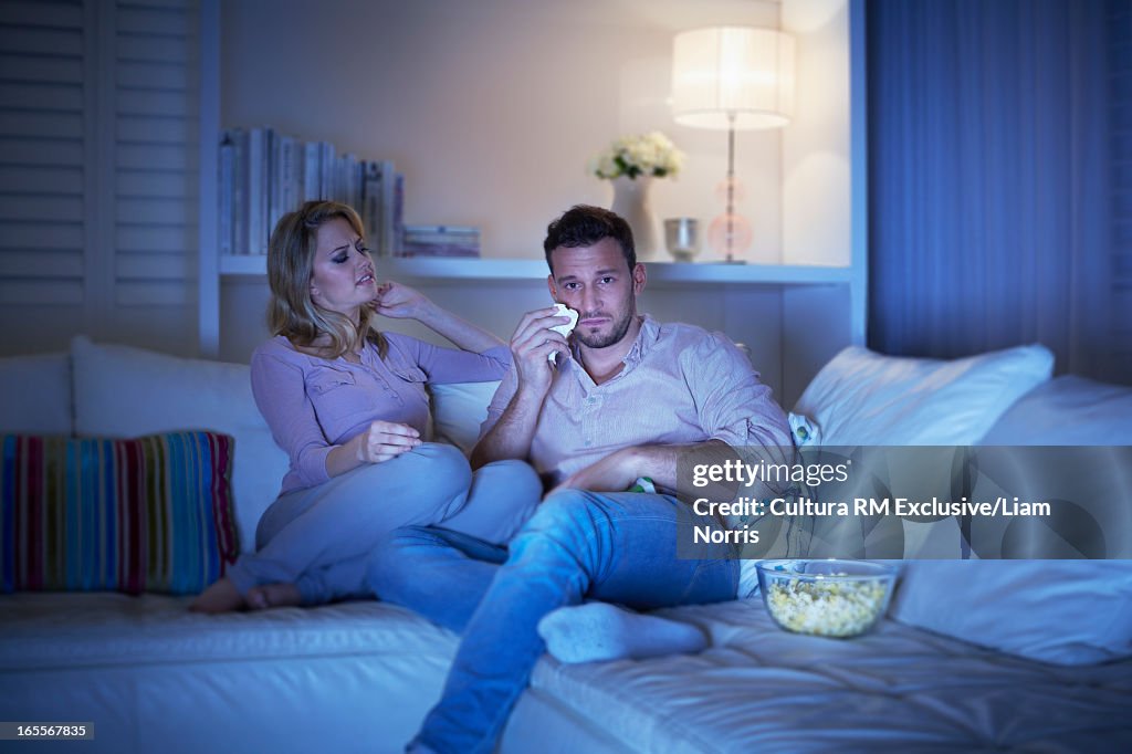 Woman watching movie with sad boyfriend