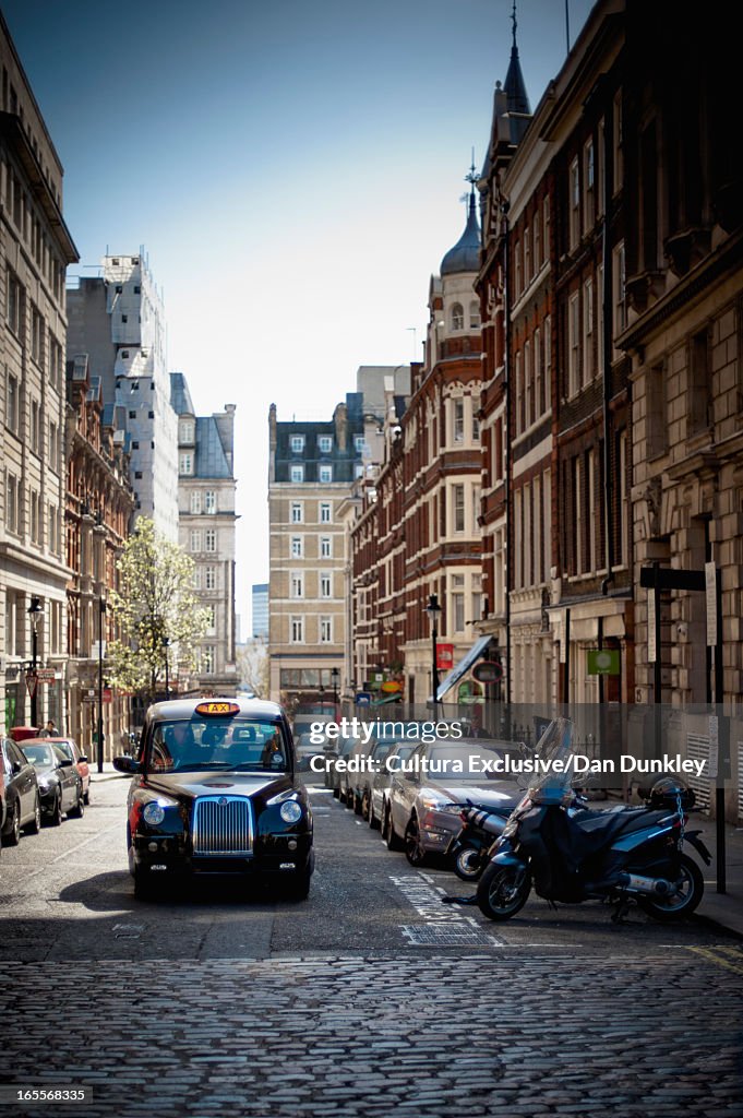 Taxi driving on cobbled London street