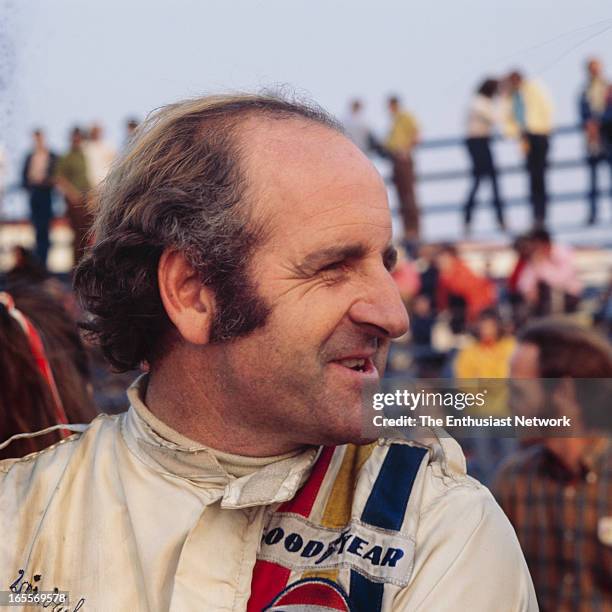Times Grand Prix - Riverside - Can-Am. Denny Hulme of the Gulf-McLaren team stands around the pits.