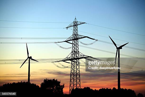 transmission tower and windcraft sillouette at dusk - high voltage sign stock pictures, royalty-free photos & images