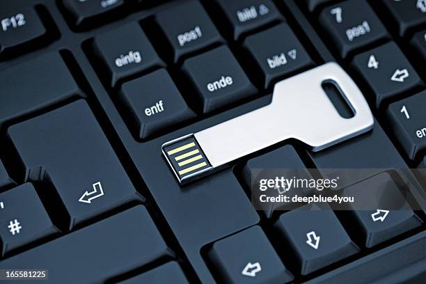 metal usb flash storage key on black keyboard - usb cable stock pictures, royalty-free photos & images