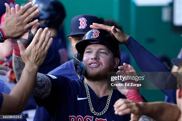 Alex Verdugo of the Boston Red Sox celebrates with teammates after scoring in the first inning against the Kansas City Royals at Kauffman Stadium on...