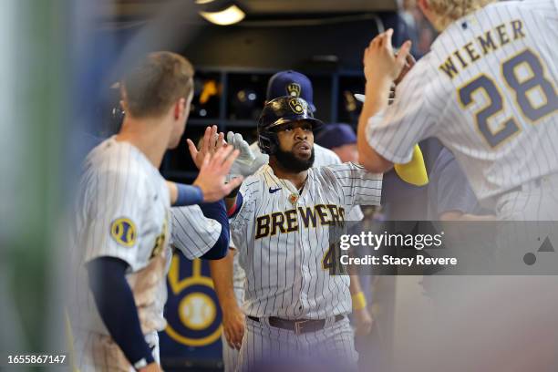 Carlos Santana of the Milwaukee Brewers is congratulated by teammates following a two run home run against the Philadelphia Phillies during the fifth...