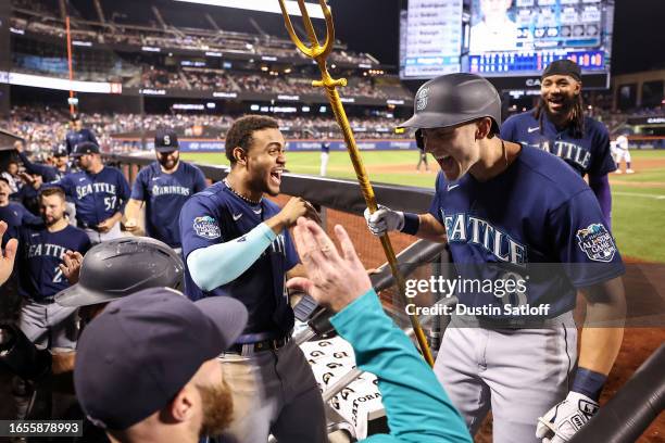 Dominic Canzone of the Seattle Mariners celebrates with the team trident as he enters the dugout after hitting a home run during the sixth inning of...