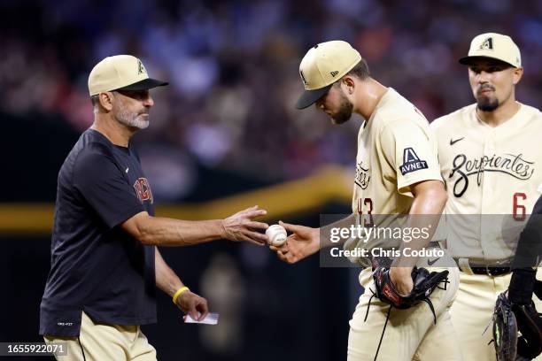 Manager Torey Lovullo of the Arizona Diamondbacks takes the ball from Slade Cecconi during a pitching change in the fourth inning against the...