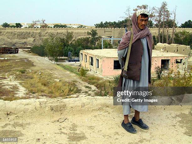 An Afghan soldier stands guard on the Qala Jiangi fortress wall overlooking the memorial to CIA agent Mike Spann and the makeshift prison where he...