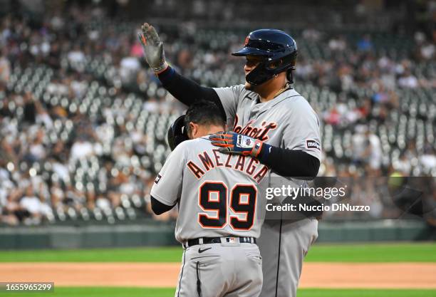 Miguel Cabrera of the Detroit Tigers reacts with first base coach Alfredo Amezaga of the Detroit Tigers following an RBI single during the fourth...