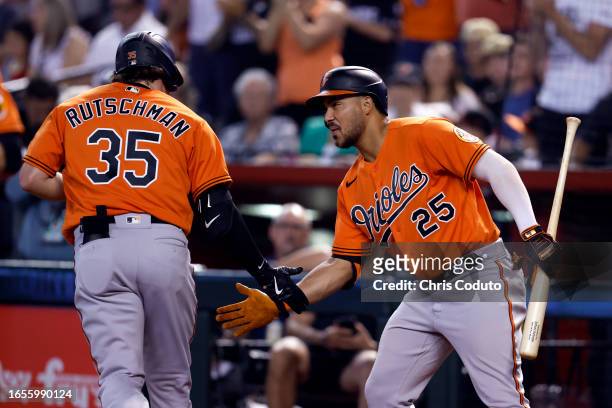 Anthony Santander of the Baltimore Orioles greets Adley Rutschman after Rutschman hit a solo home run against the Arizona Diamondbacks during the...
