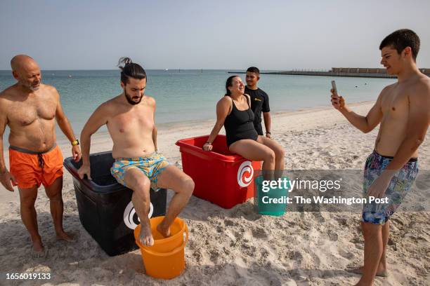 Clients prepare to fall into an ice bath prepared by Endorphins Method head first on one of the beaches in Dubai, United Arab Emirates on July 28,...