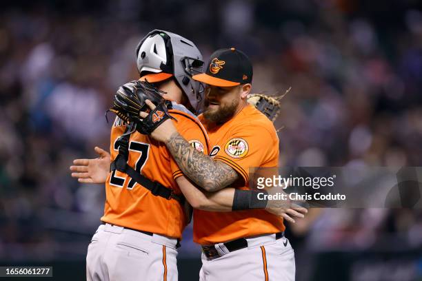 Joey Krehbiel of the Baltimore Orioles hugs James McCann after the Orioles defeated the Arizona Diamondbacks by 7-3 at Chase Field on September 02,...