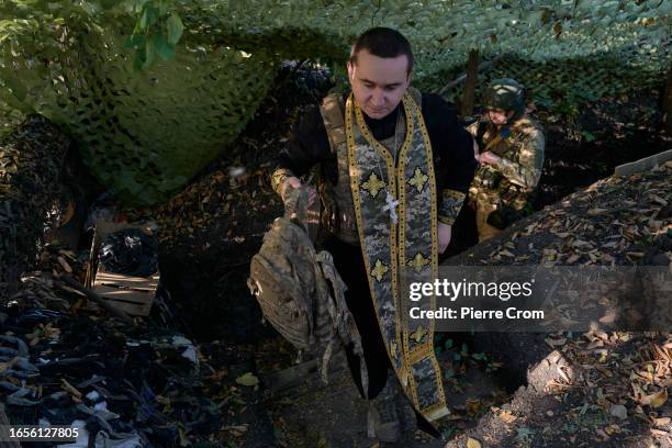 Ukrainian military chaplain Ivan prays with infantry soldiers of the "Black Zaporozhian Cossacks" 72th Brigade on the frontline near Donetsk on...