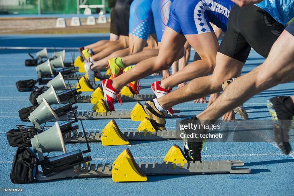 Group of eight athletes starting 100m sprint