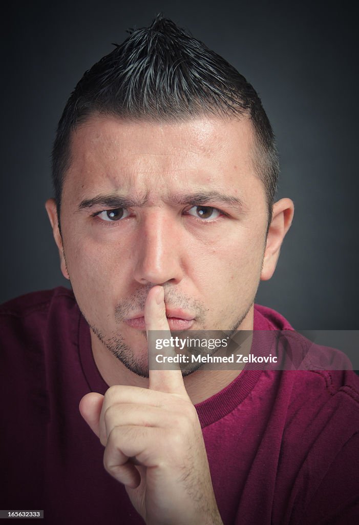 Man gesturing to be quiet