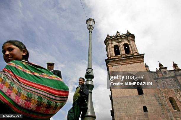 Una niña cusqueña pasa el 07 de diciembre de 2004, frente a una torre de la Catedral del Cusco, en el sur andino de Perú, donde hoy se llevará a cabo...