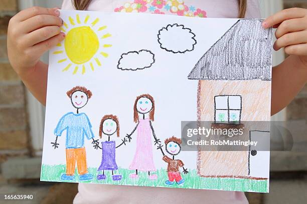 girl holds drawing of her family - crayon stock pictures, royalty-free photos & images