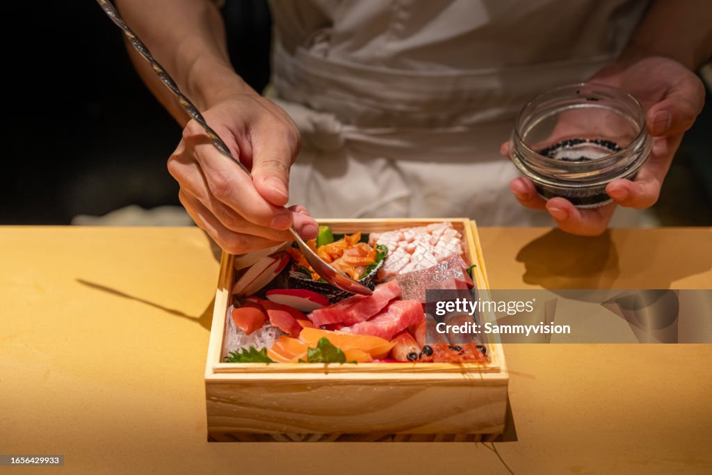Chef preparing sashimi platter in the kitchen