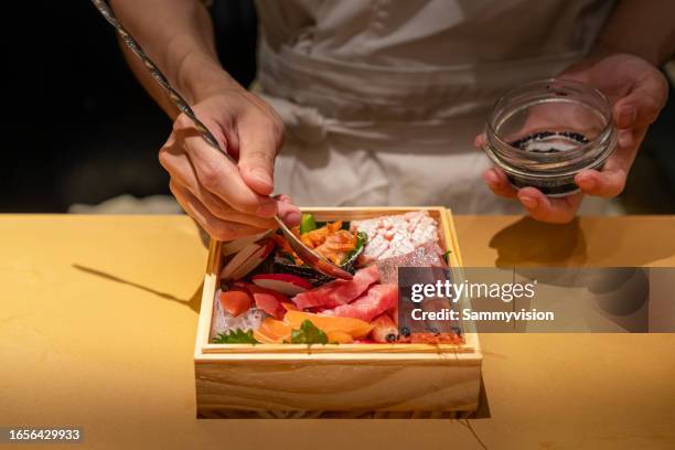 chef preparing sashimi platter in the kitchen - seafood platter stockfoto's en -beelden