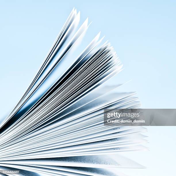 close-up of magazine pages on light blue background - magazines stockfoto's en -beelden