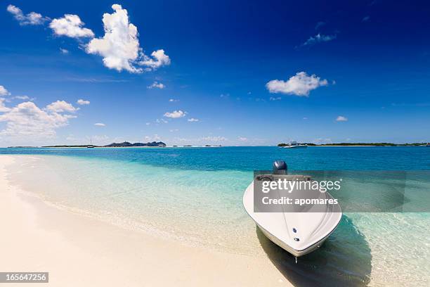 power boat in a tropical white sand cay beach - cay stock pictures, royalty-free photos & images