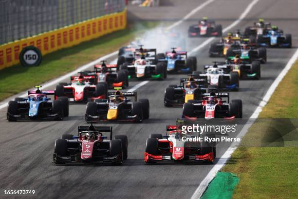 Theo Pourchaire of France and ART Grand Prix and Oliver Bearman of Great Britain and PREMA Racing lead the field into turn one at the start during...