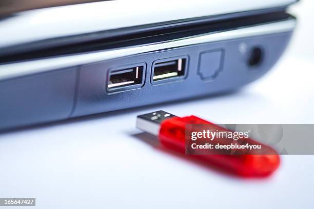 uma red pen drive perto de um computador portátil, close-up com avião de foco. - pen drive - fotografias e filmes do acervo