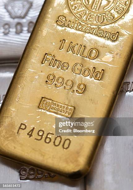 One kilogram gold bar sits on top of silver bars at London bullion dealers Gold Investments Ltd. In this arranged photograph in London, U.K., on...