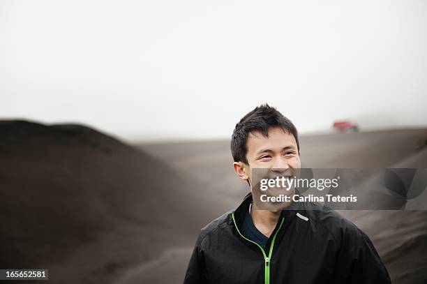 a man standing on a black sand dune - vietnamesischer abstammung stock-fotos und bilder