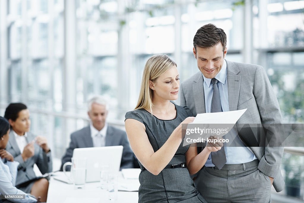 Executives going through a document with team in meeting