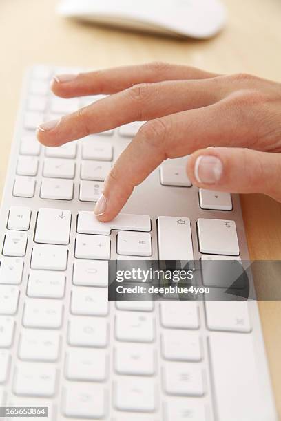 femme en appuyant sur le bouton de retour sur un clavier blanc - postit photos et images de collection